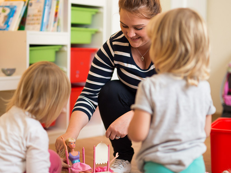 Kinder spielen mit Betreuerin