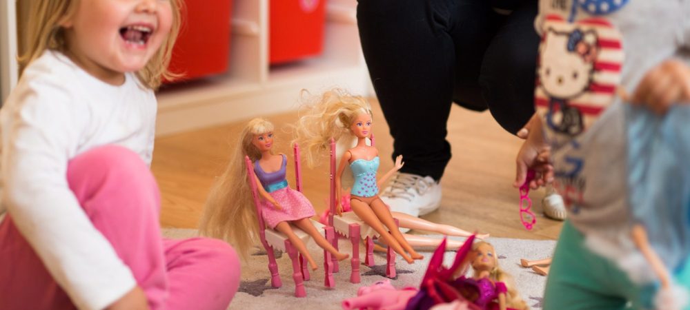 Kinder spielen mit Barbies